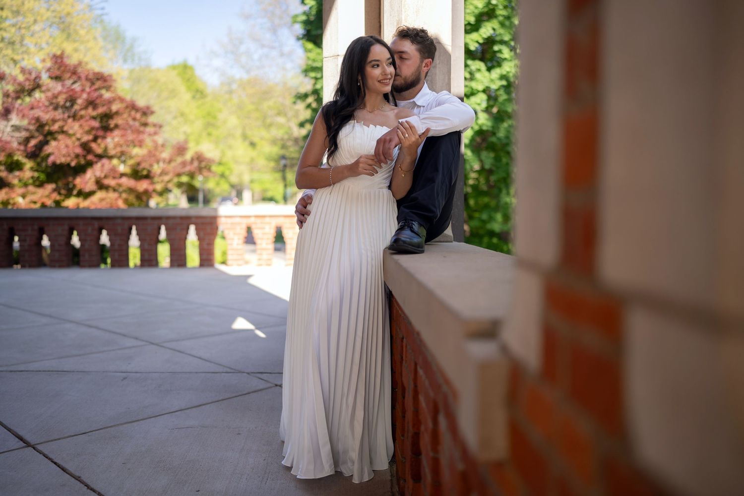 engaged couple shares a romantic embrace on an elegant outdoor terrace at Jeffrey Mansion