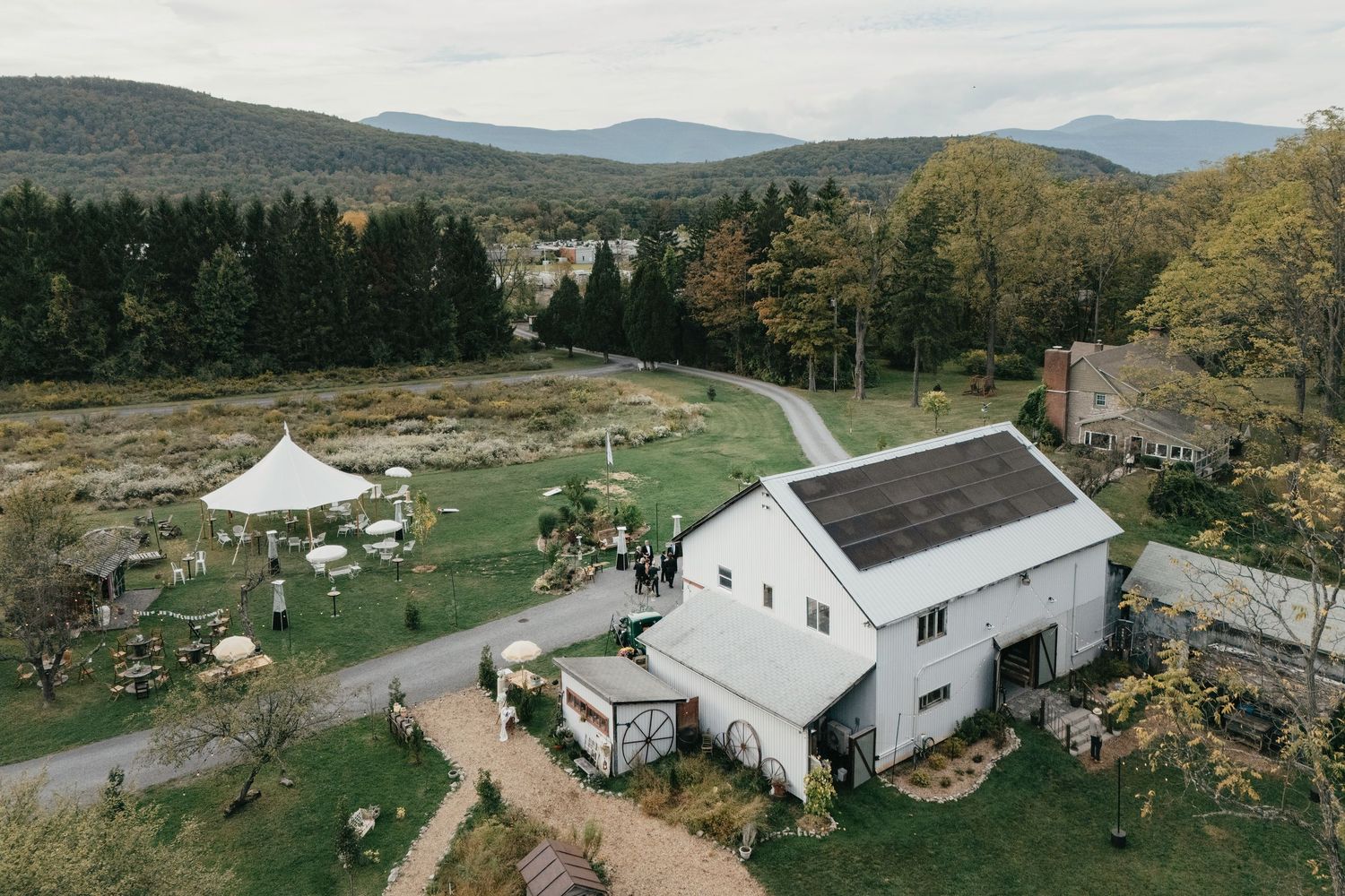 Aerial view of a historic gray stone castle with a tower and arched entrance, surrounded by lush green golf course grounds.