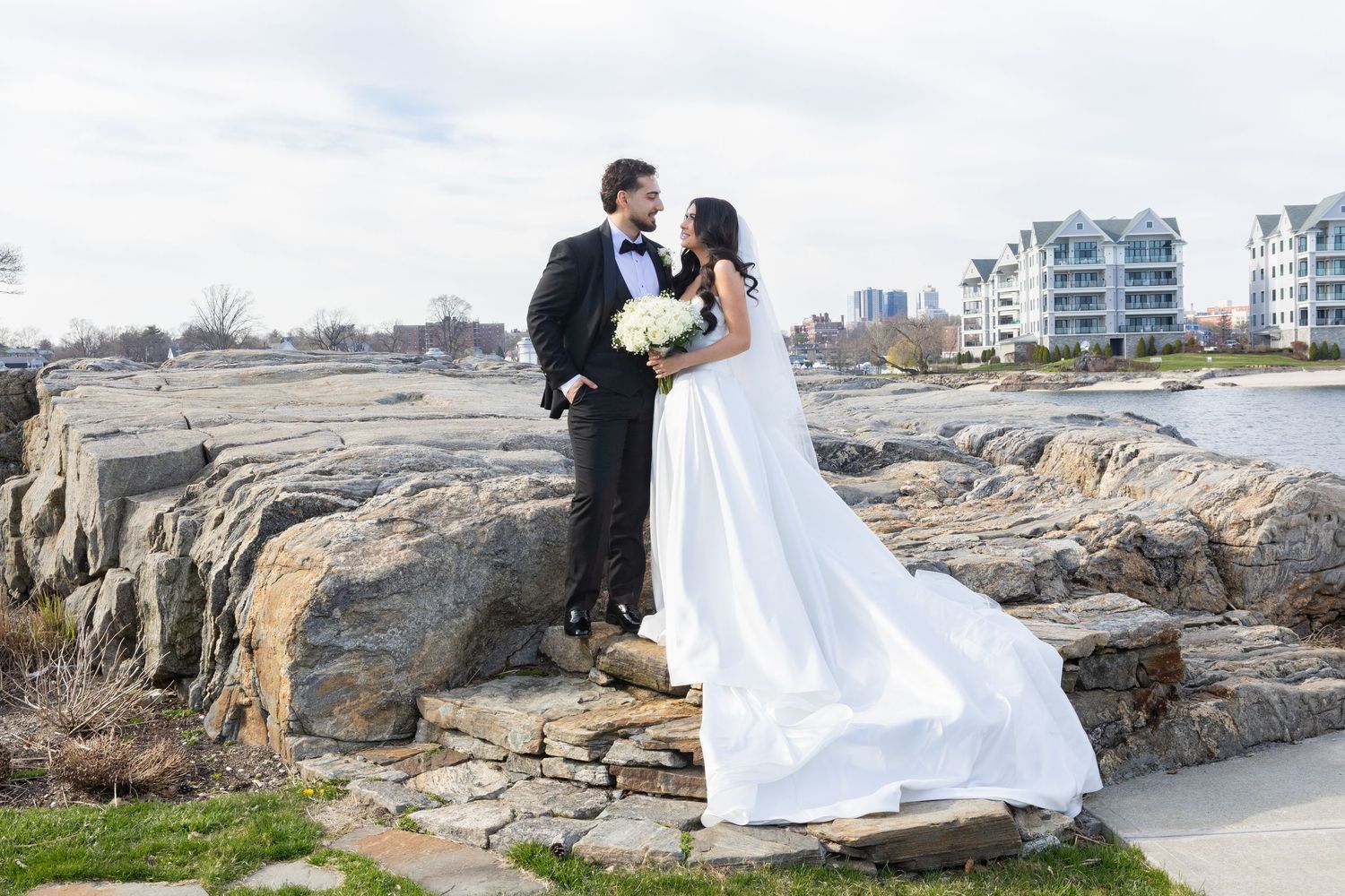 Bride and groom portrait on the waterfront rocks at Glen Island Harbour Club in New Rochelle