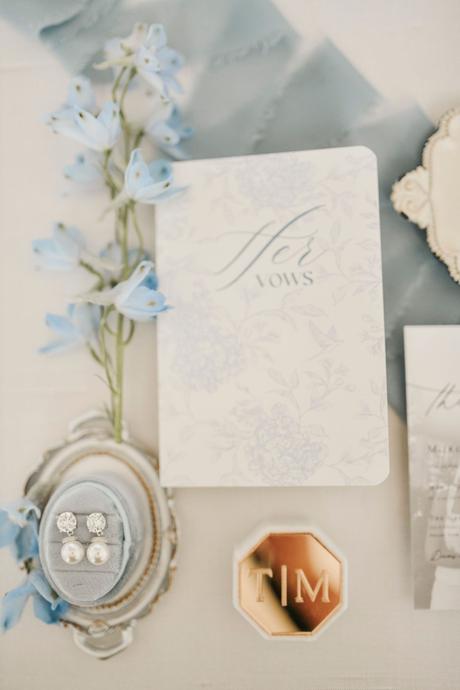 airy blue and ivory wedding detail styling with ribbon and floral accents