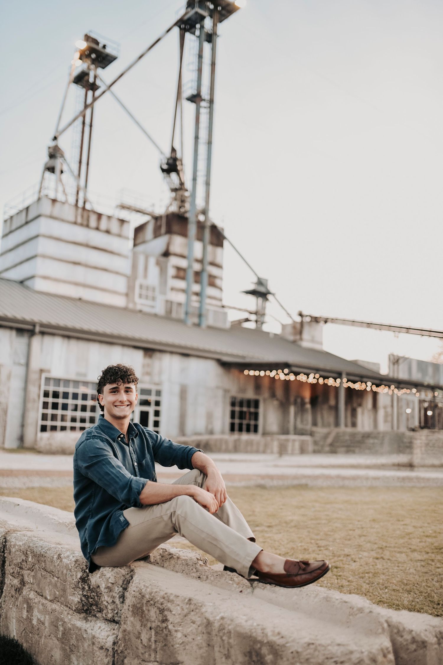 Senior boy portrait session near TUPPS Brewery in McKinney Texas with outdoor industrial seating