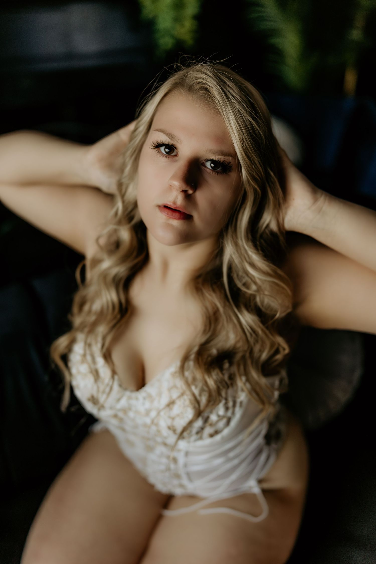 A portrait featuring soft lighting and delicate lace details in an intimate boudoir setting.