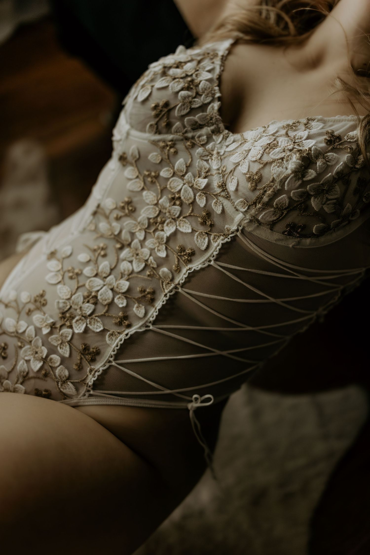 Close-up detail of intricate beadwork and floral embellishments on a wedding dress.