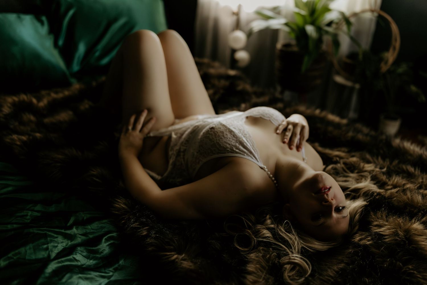 Dramatic boudoir photography sequence with dark green tones and natural foliage elements.