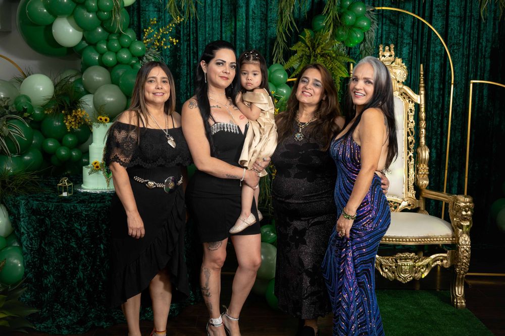 Group photo session at an elegant green-themed celebration with gold decorative elements.