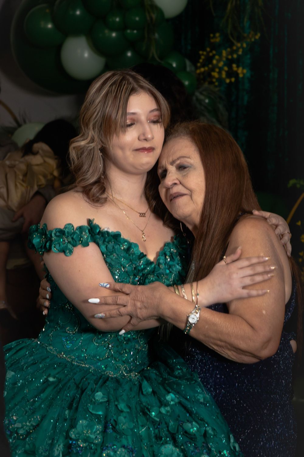 Emotional moment captured during a special celebration with emerald green formal attire.