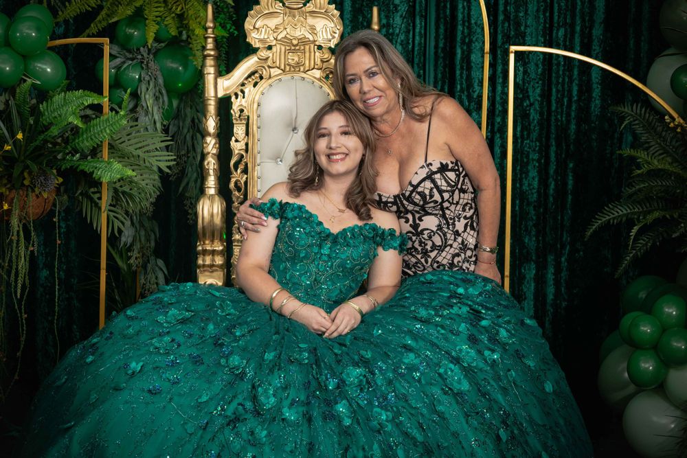 Celebration scene with emerald green balloons and decorations against a dark backdrop with gold accents.