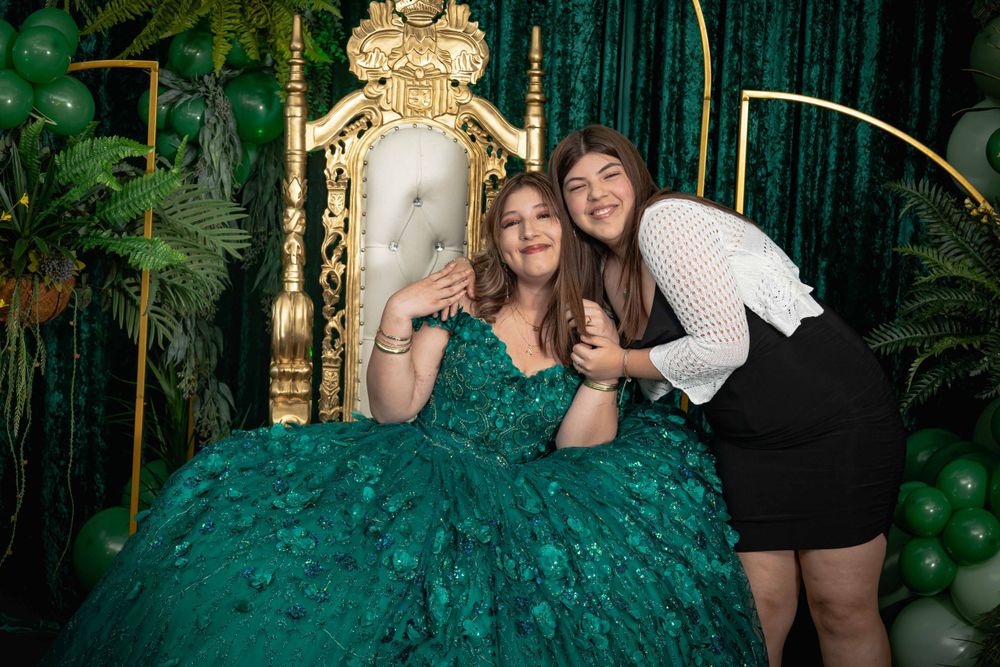 Elegant party setup featuring emerald green tulle dress and balloon garland decorations.