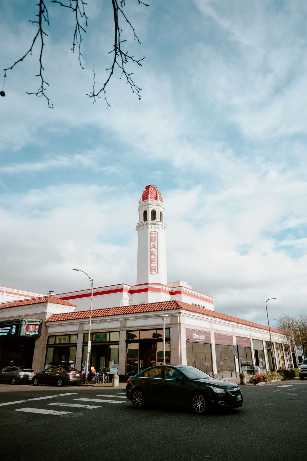 Art deco style gas station building with red and white tower under blue sky.