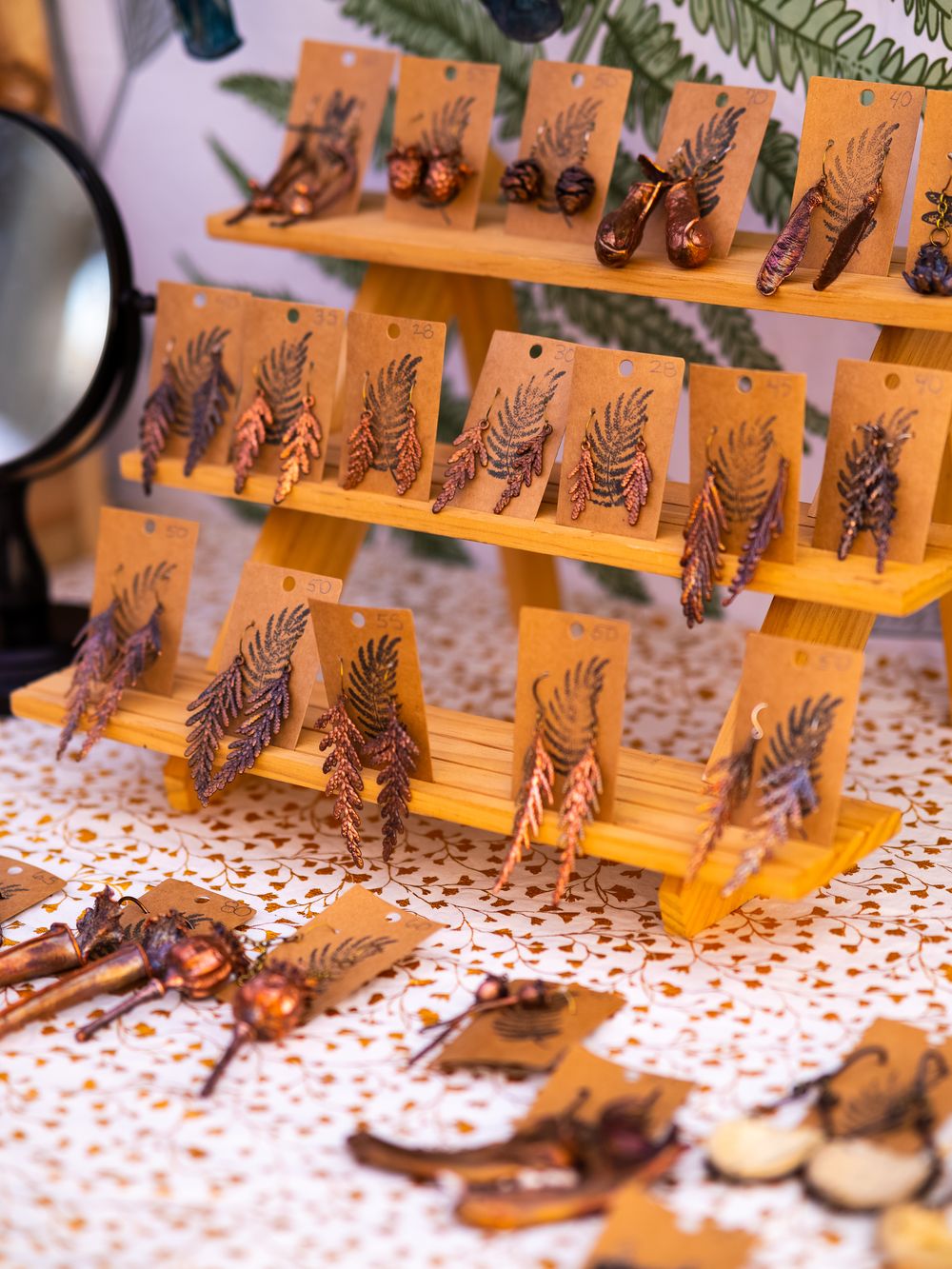 Wooden display stands with intricate carved animals arranged on a patterned tablecloth.