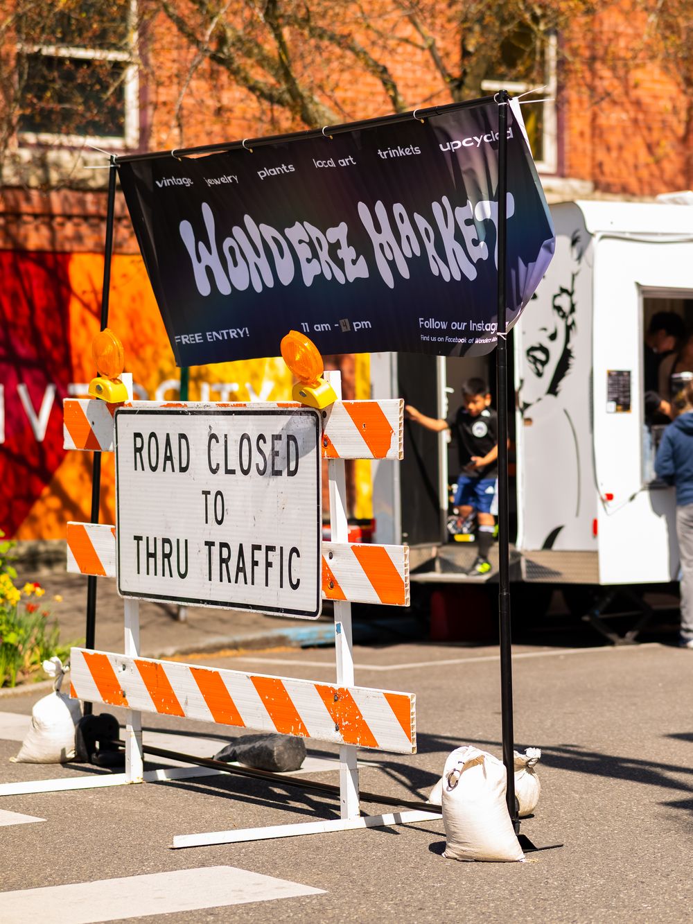 Road closed and traffic signs at outdoor street market.