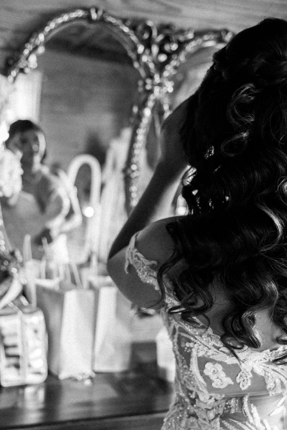 Artistic black and white wedding photo with ornate mirror reflection.