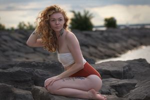 Outdoor portrait of a woman with natural sunlight illuminating her face and hair.