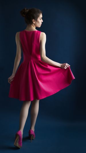 Portrait of a woman in a dress, standing with a relaxed posture.