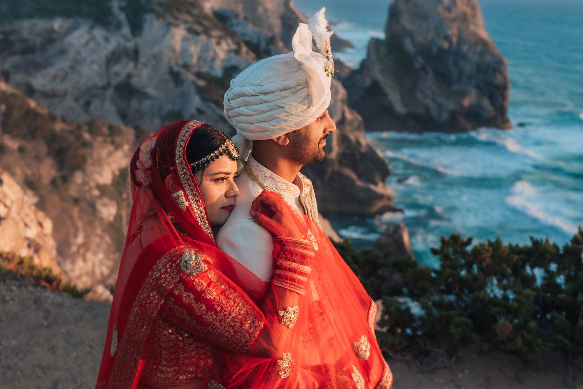 A breathtaking beach photoshoot during a Destination Indian Wedding in Portugal, with the couple embracing against the  coastal backdrop