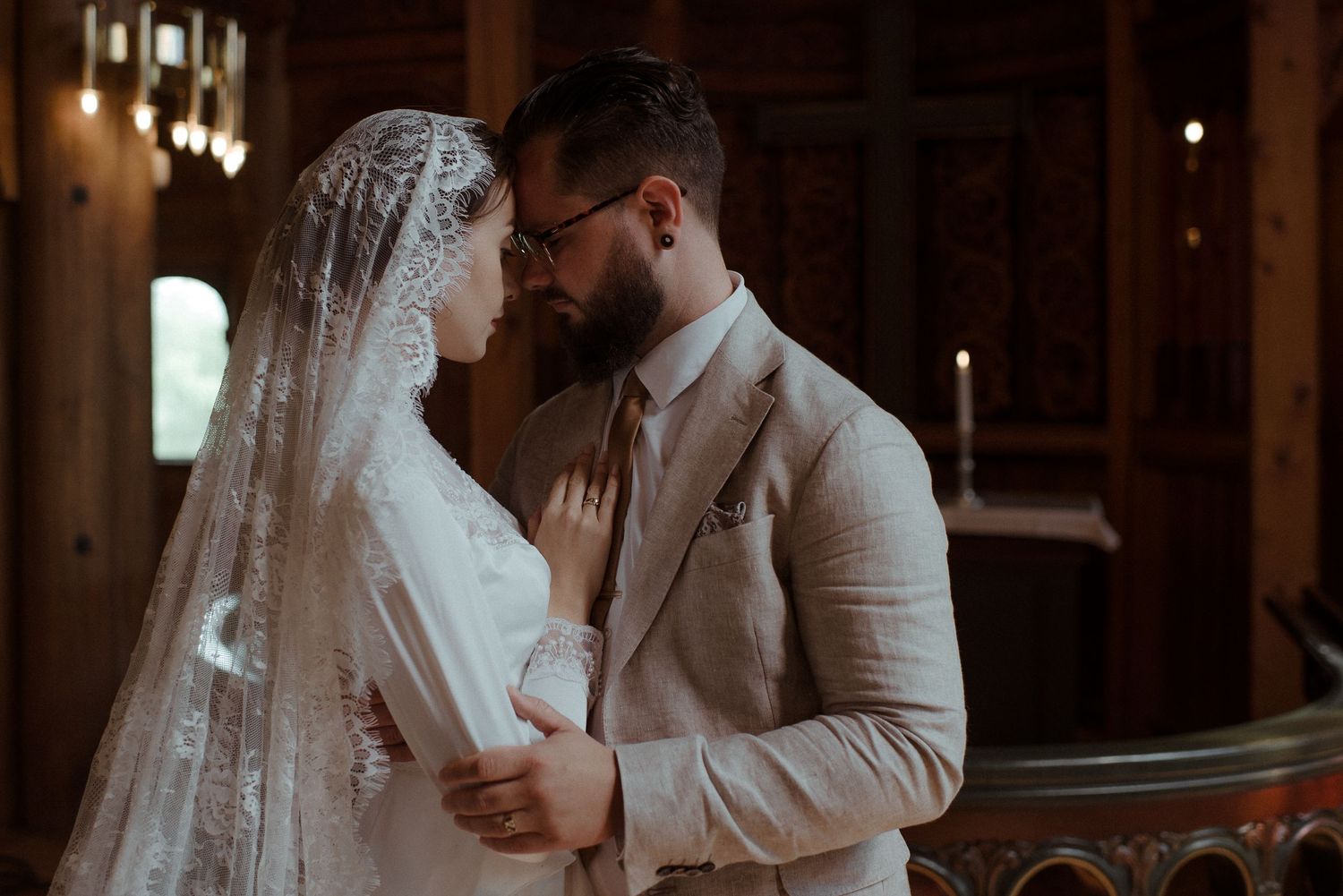 An intimate wedding moment captured in a rustic wooden barn setting.