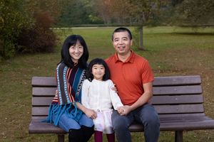 A series of outdoor family photos taken on a wooden park bench during autumn with colorful fall foliage in the background.
