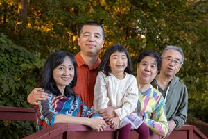 A group of people sitting together outdoors in a park setting during autumn.