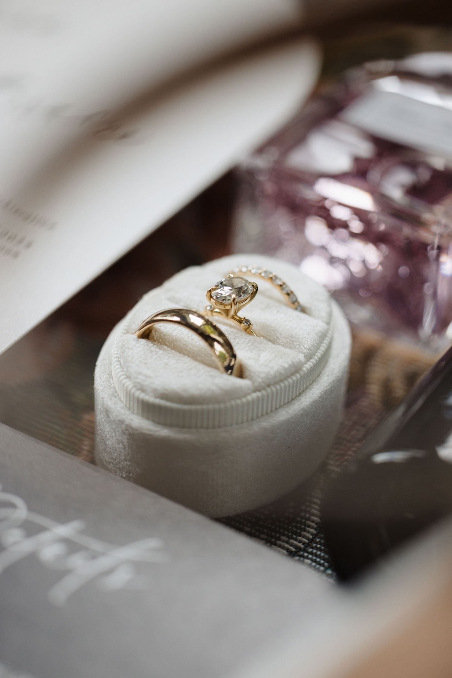 Wedding rings nestled in a white cushioned ring box with delicate diamond detail.