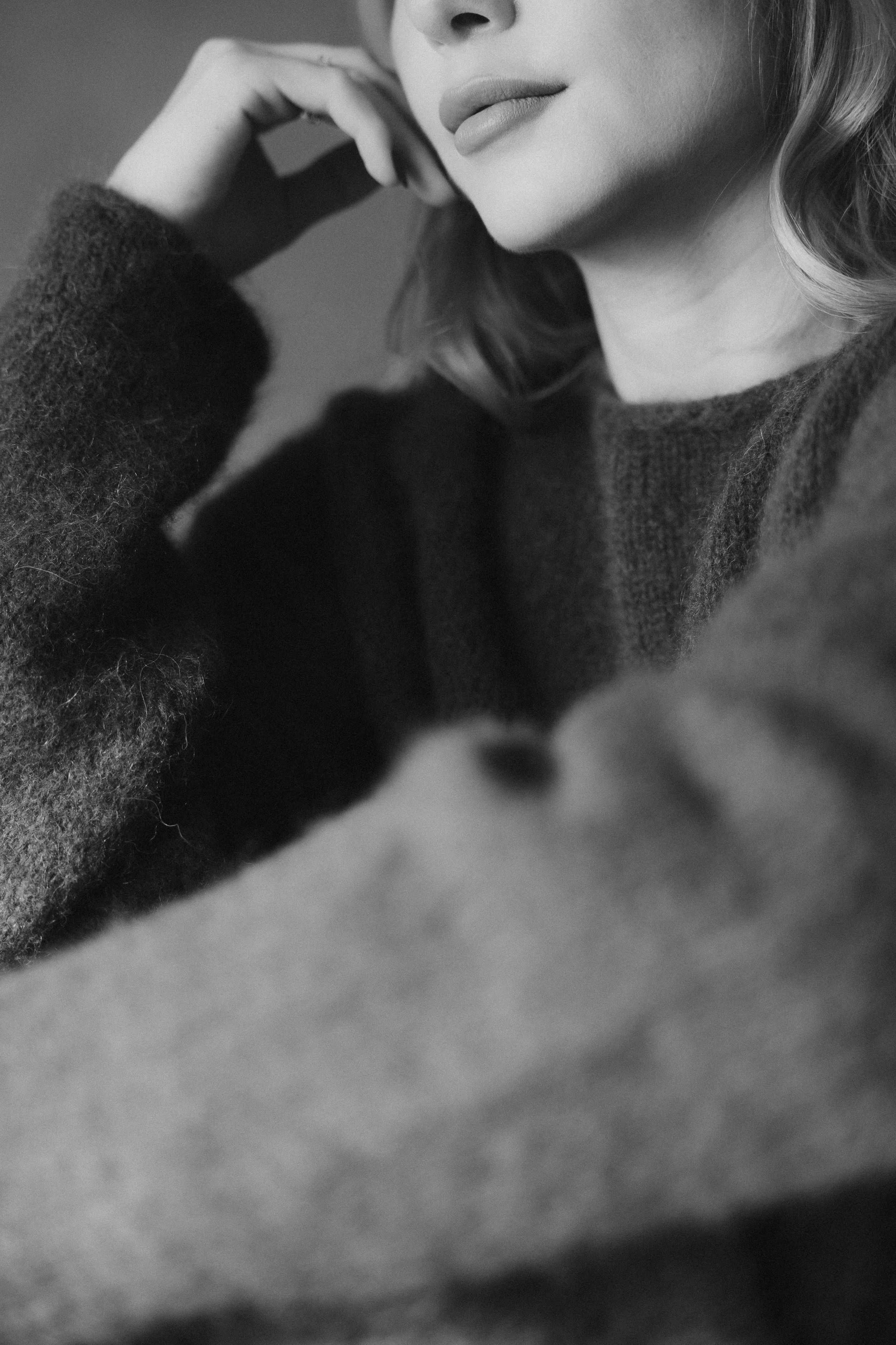 Black and white portrait series showing close-up details of a person wearing a dark sweater in moody lighting.