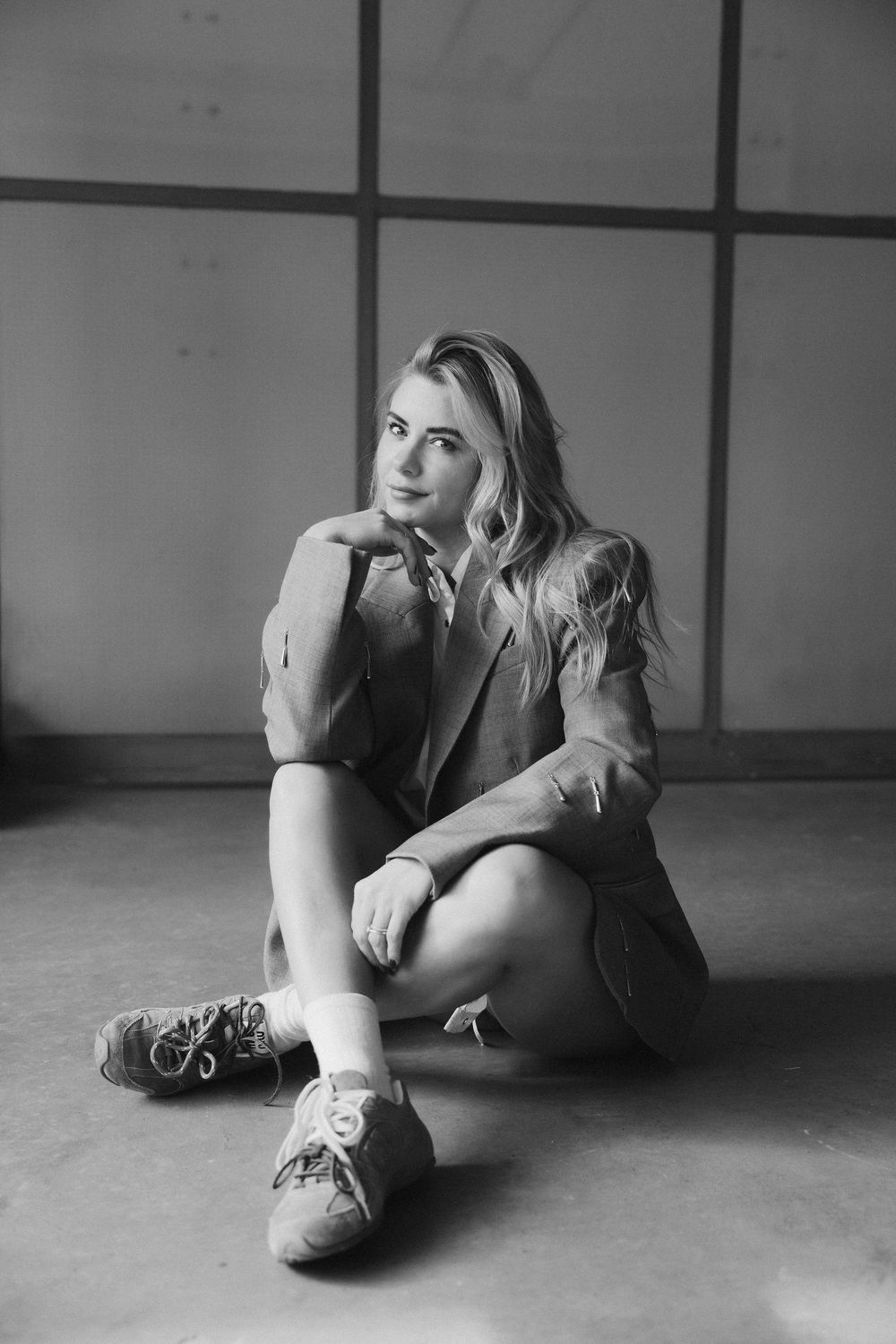 A black and white photo series showing a person lying on the floor in different curled up positions.