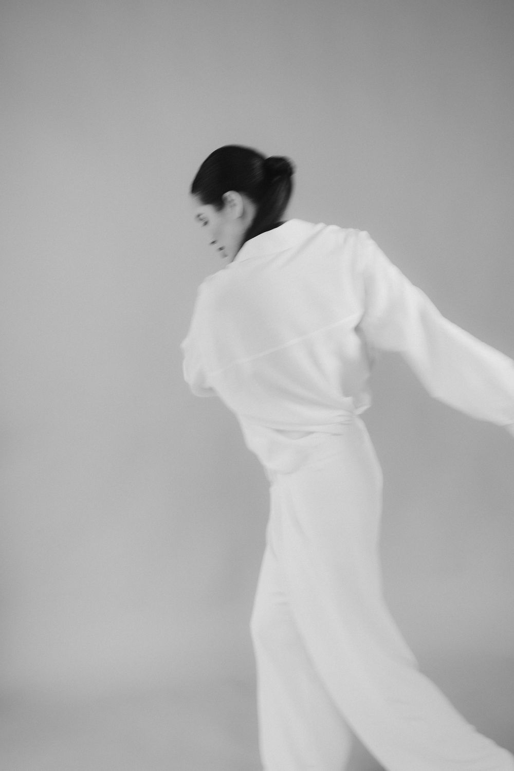 Dynamic motion capture in white clothing against grey background.