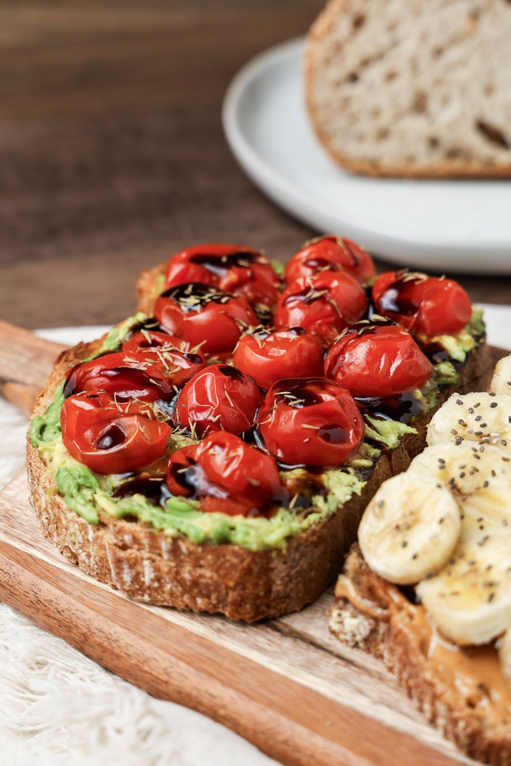 Artisan toast topped with mashed avocado and roasted cherry tomatoes drizzled with balsamic.