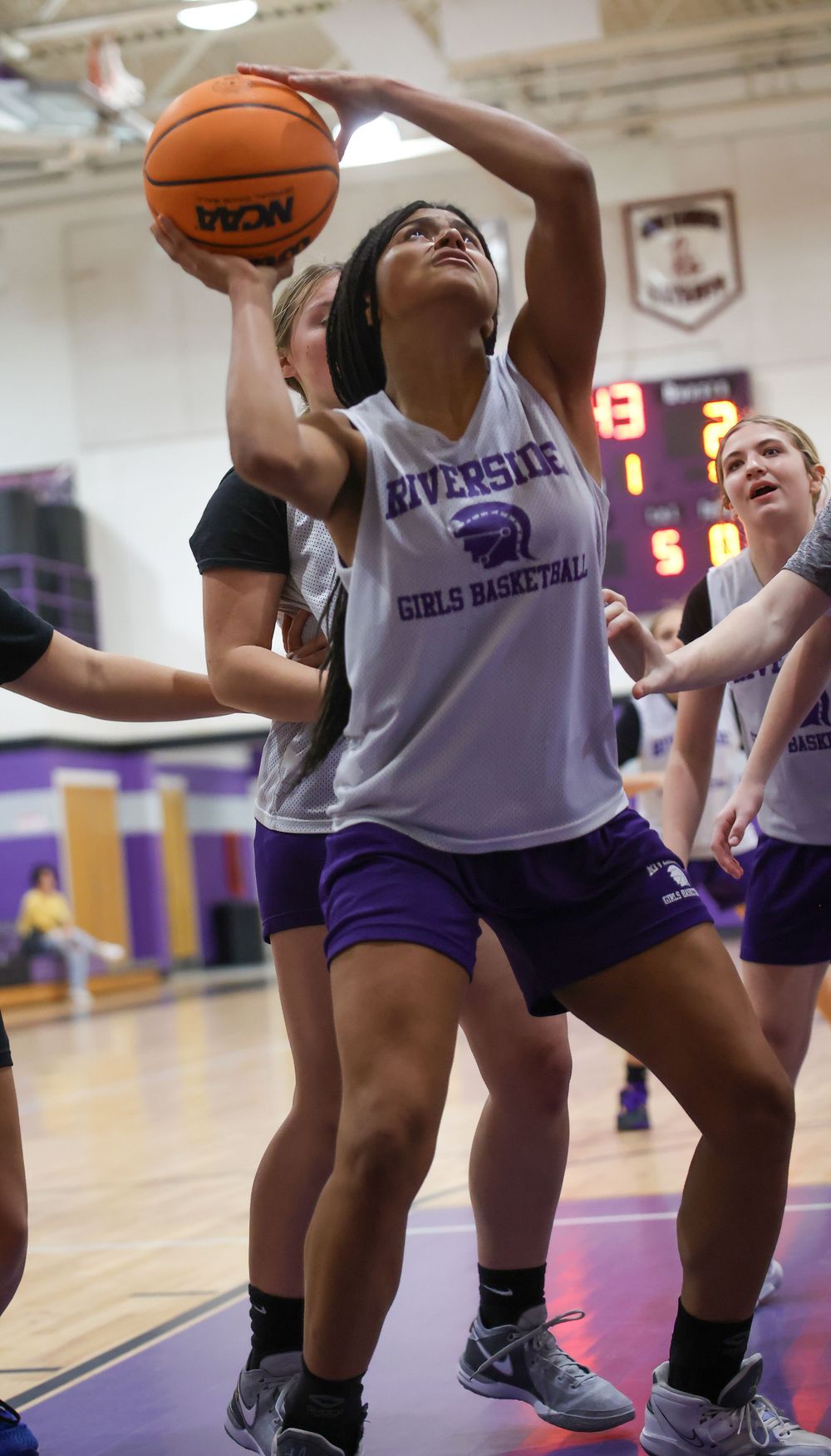 Basketball player in Riverside uniform prepares to score during competitive game action.