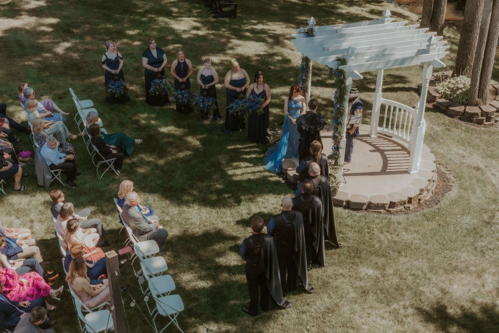 Aerial view of a garden wedding ceremony with guests seated around a white gazebo.