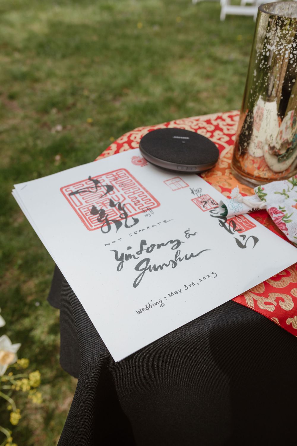 A wedding invitation featuring red Asian-inspired artwork and calligraphy on white paper.