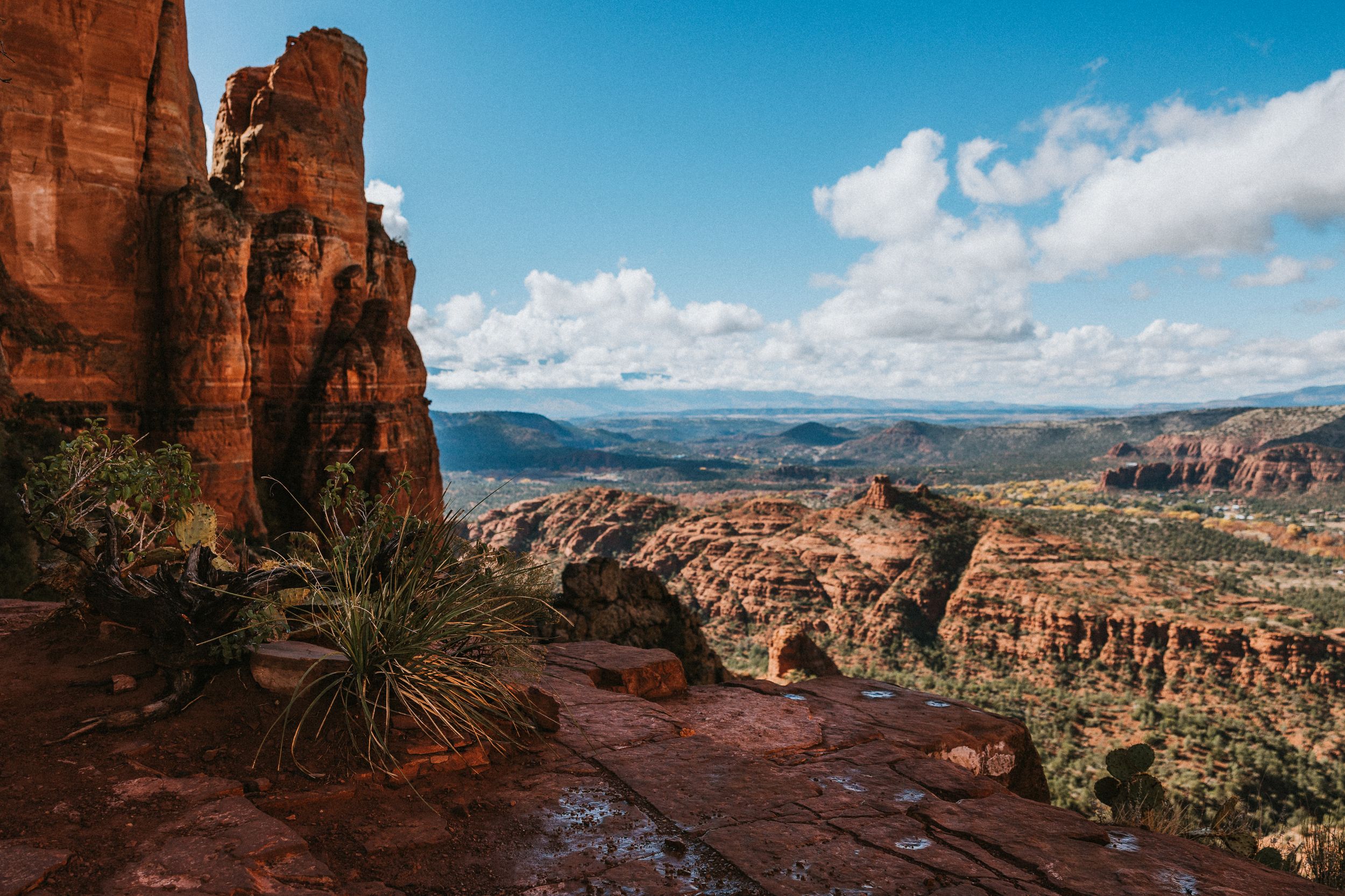 Panoramic vista of red rock canyons and desert landscape under blue skies.