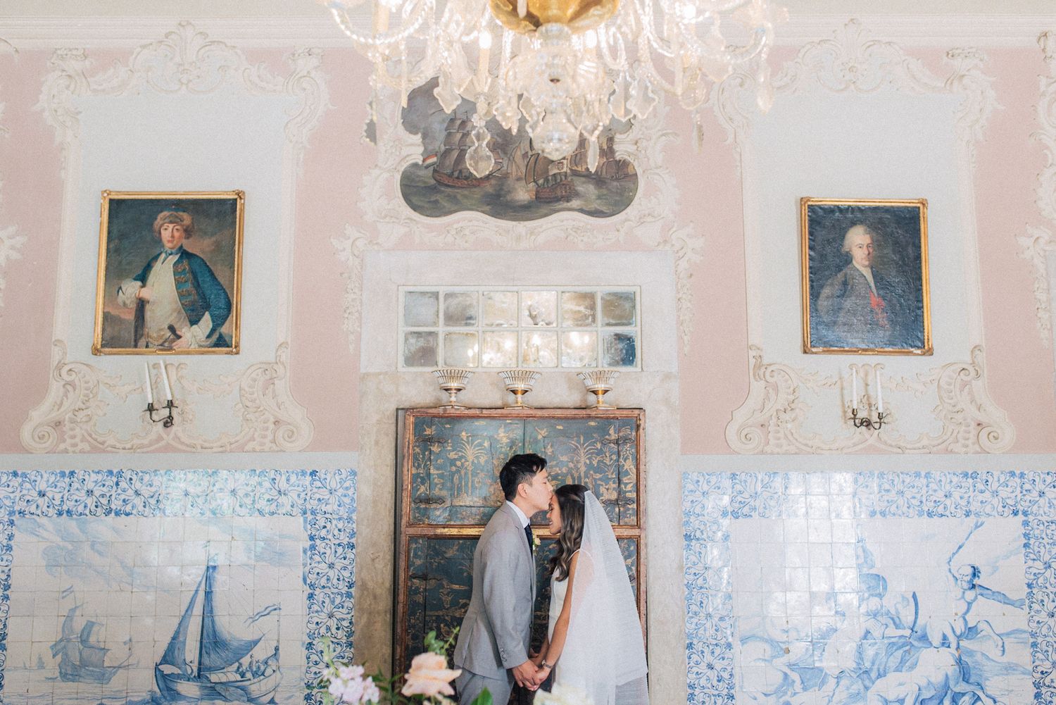 A romantic couple shares a moment in an ornate room with tiled walls at fonteira palace, captured by a Portugal Wedding Photographer