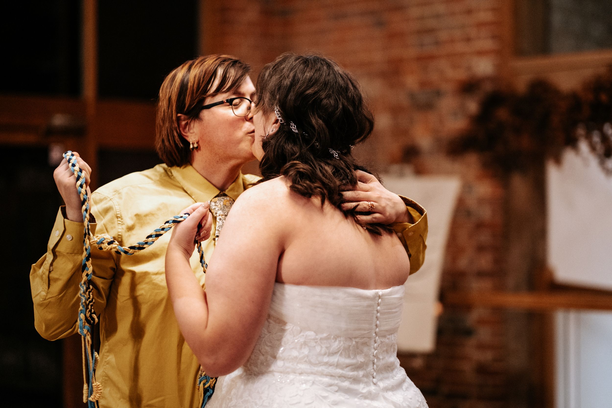 Intimate fantasy wedding moments captured in a rustic brick-walled venue.