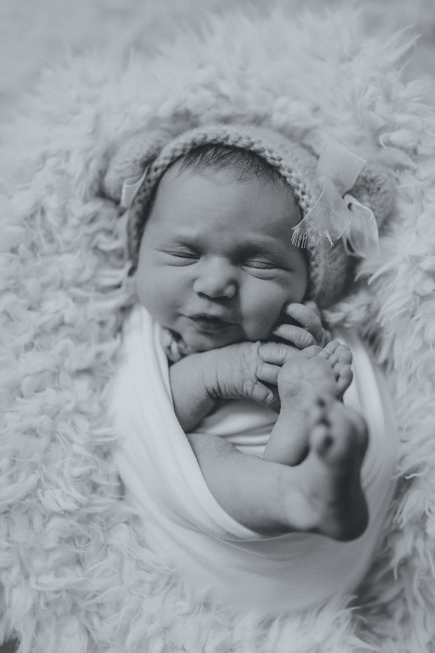 Black and white portrait of a sleeping newborn baby nestled in soft white fur. Photographer. Hull. East Yorkshire. Photography