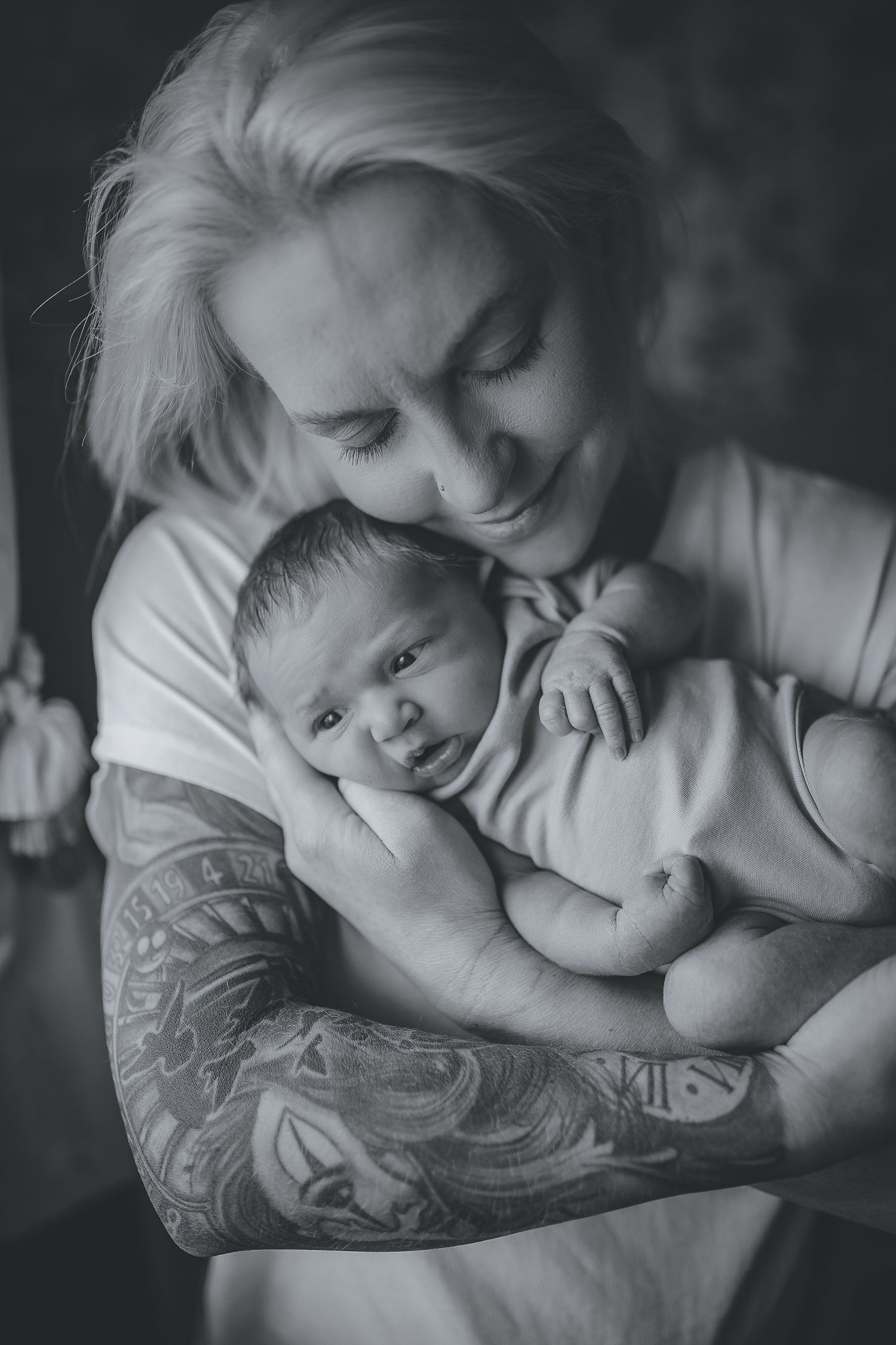 Black and white series showing parent with tattoo sleeve cradling sleeping infant. Photographer. Hull. East Yorkshire. Photography