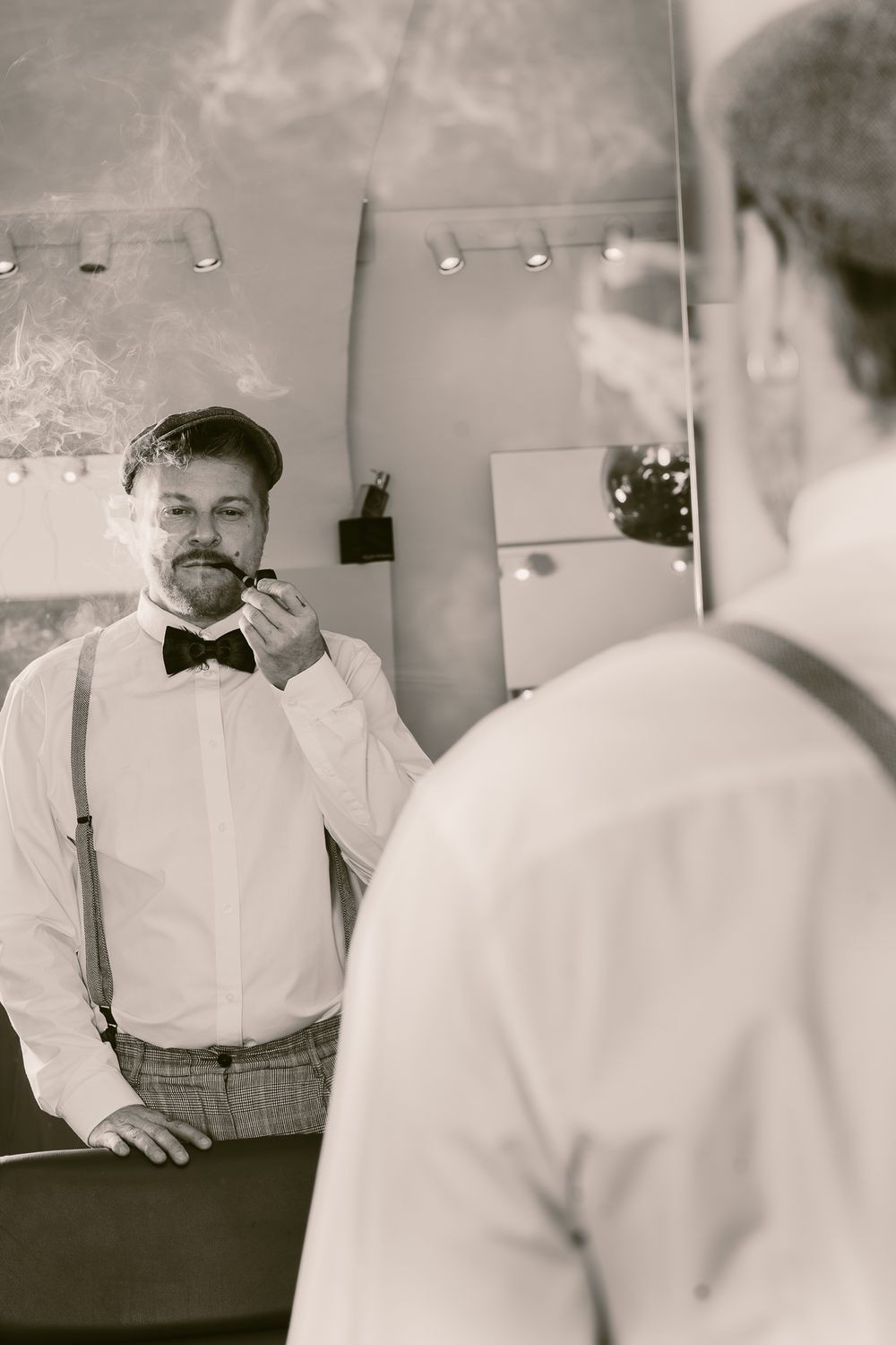 Men Fotografie. Black and white photo showing a reflection in a mirror of someone adjusting their bow tie.