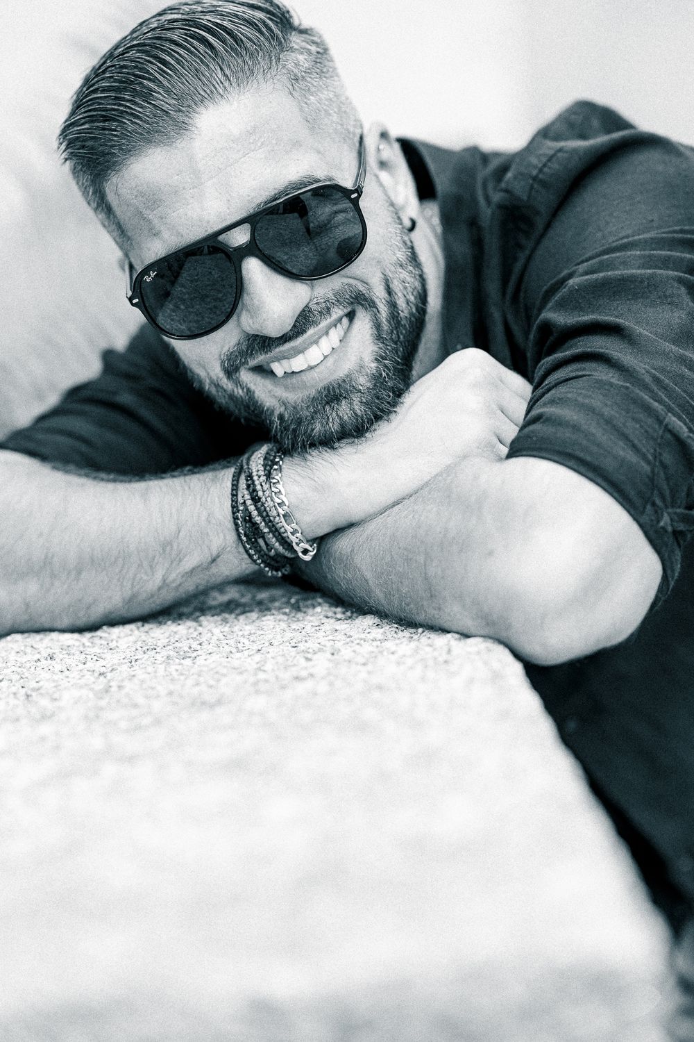 Men Fotografie. Black and white casual portrait with sunglasses showing a genuine smile.