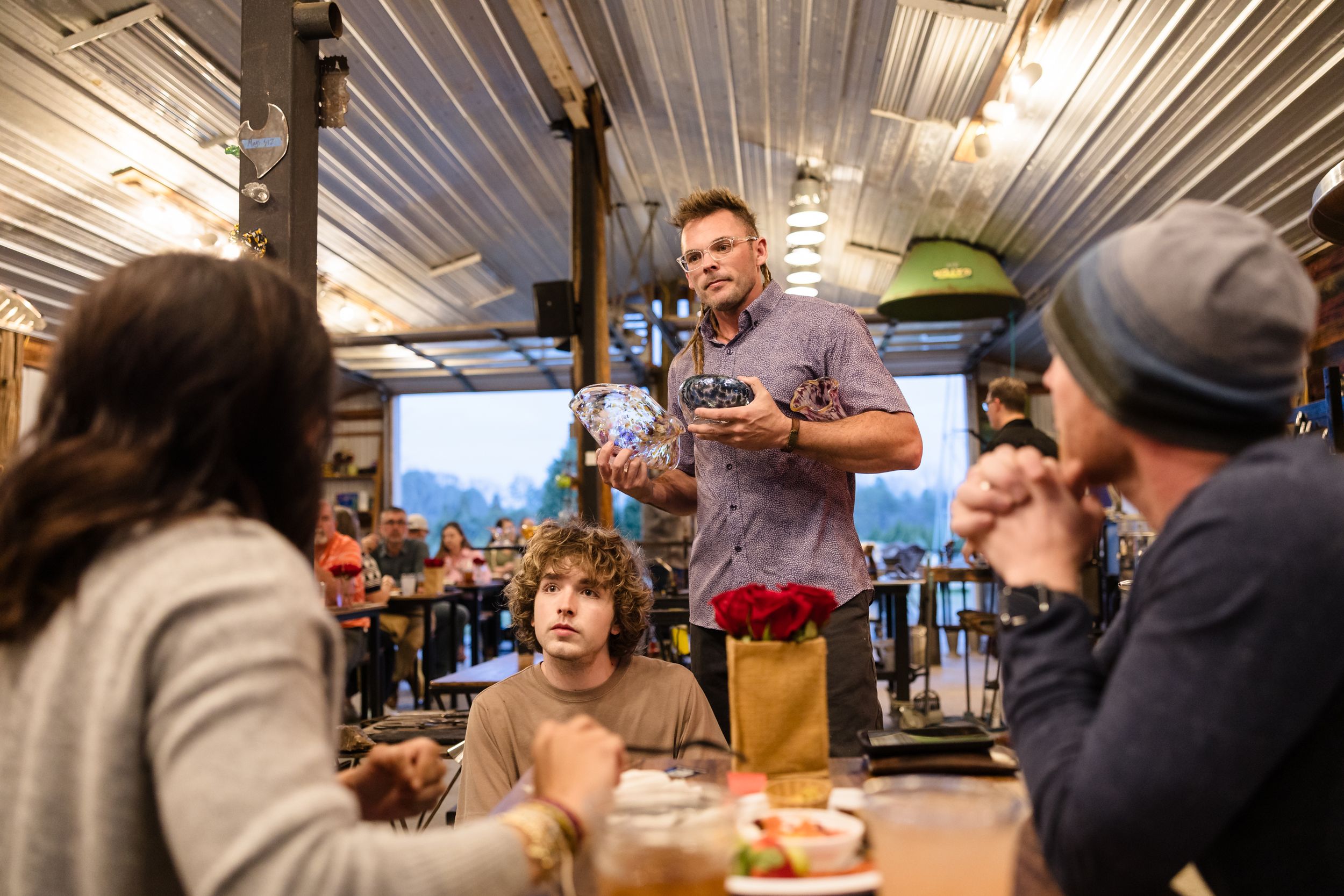 People gathered at a rustic bar counter enjoying drinks and conversation in a cozy pub setting.