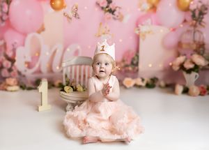 Image of little girl at her cake smash celebrating one year old birthday party in Shelly Loxton Photography Studio in Coventry