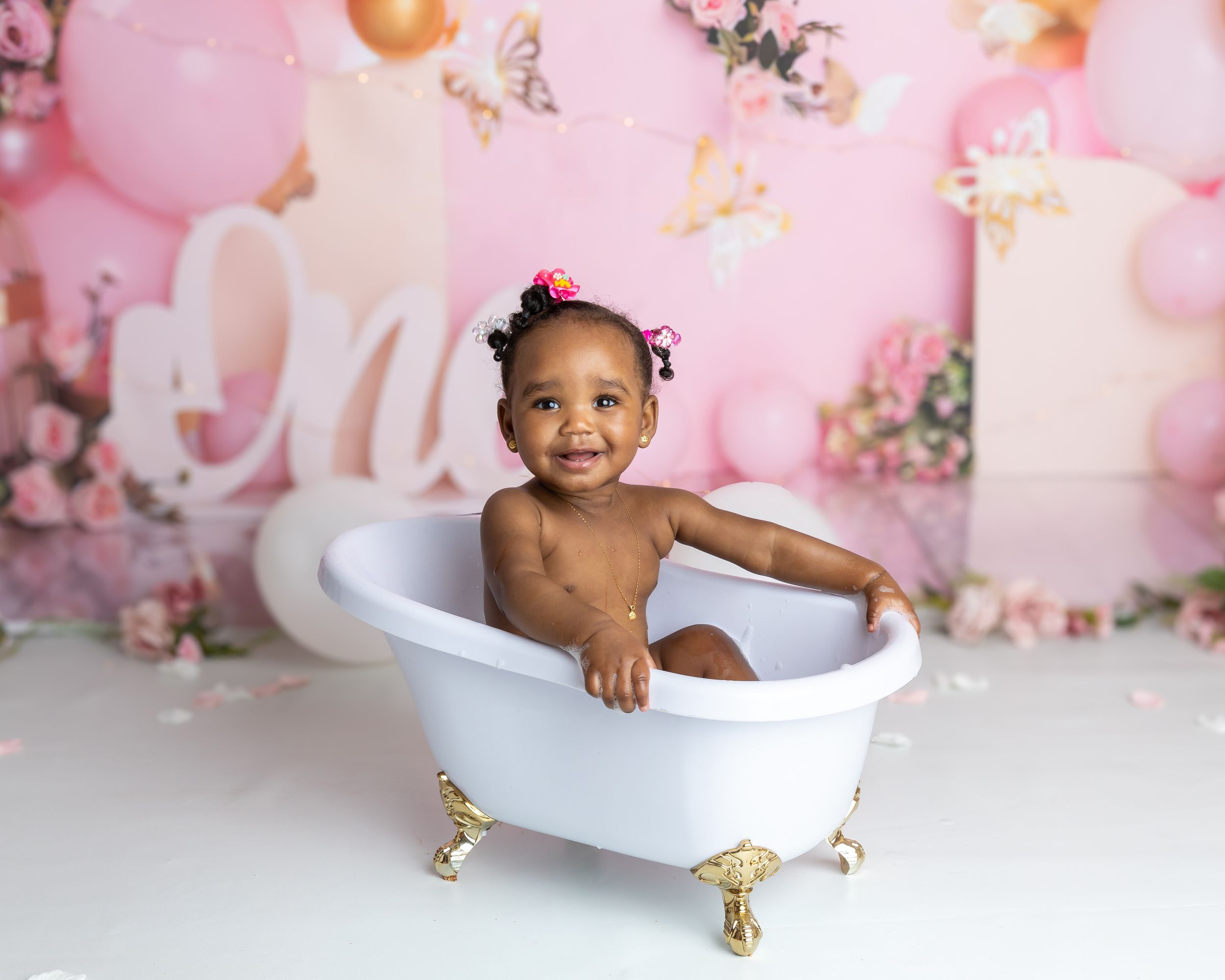 Picture of little girl in the splash bath at her cake smash celebrating one year old birthday party in Coventry