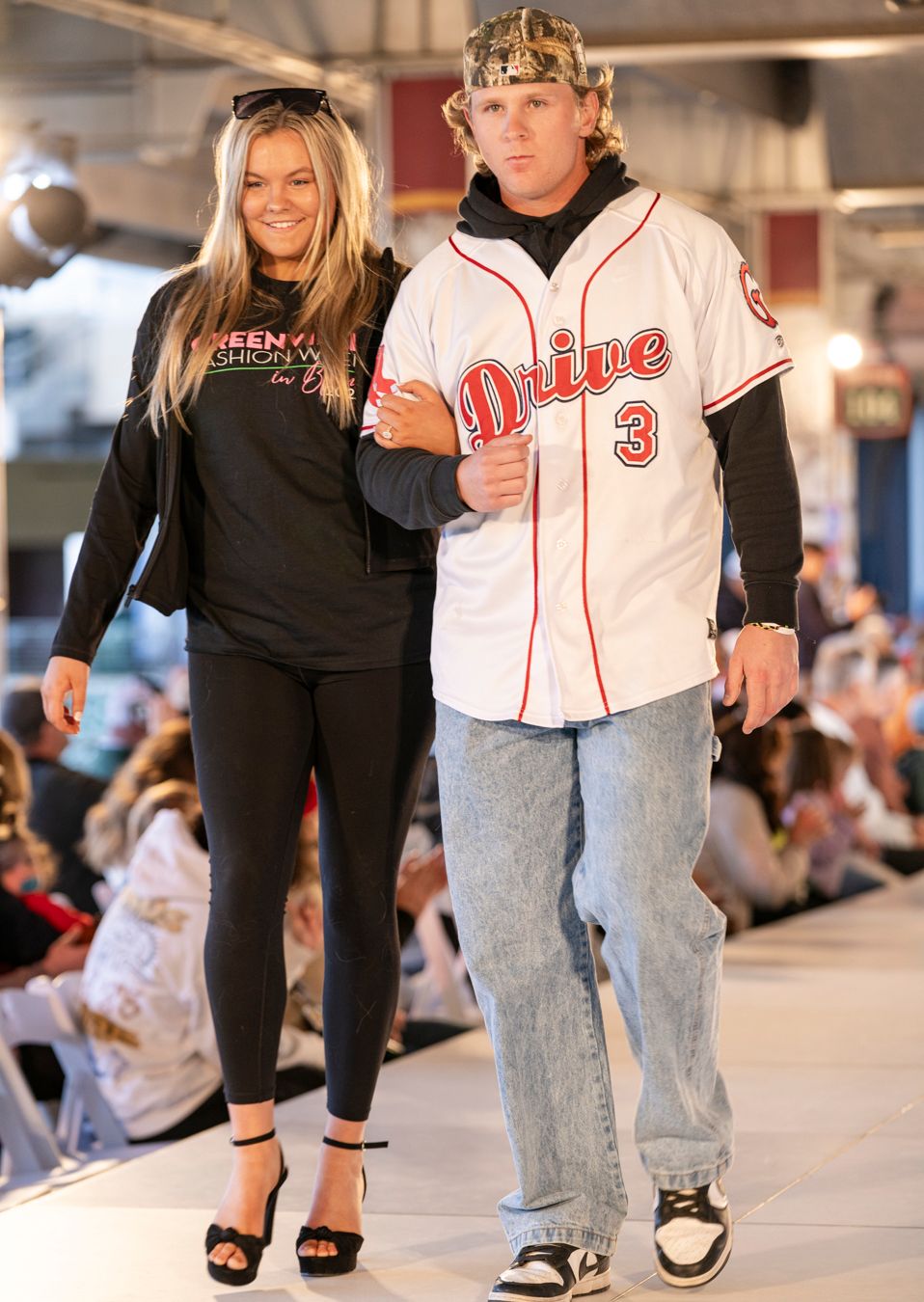 Fashion models showcase contrasting casual and athletic wear combinations on a brightly lit catwalk.