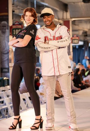 Fashion show features models in baseball uniforms paired with contemporary casual attire.