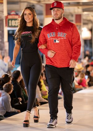 Models showcasing casual athletic wear and Boston Red Sox themed apparel on an indoor catwalk.