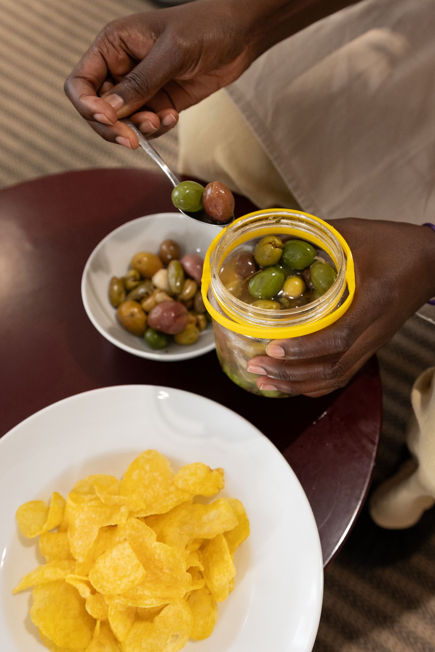 Step-by-step sequence showing tortilla chips being topped with pickled vegetables from a jar.