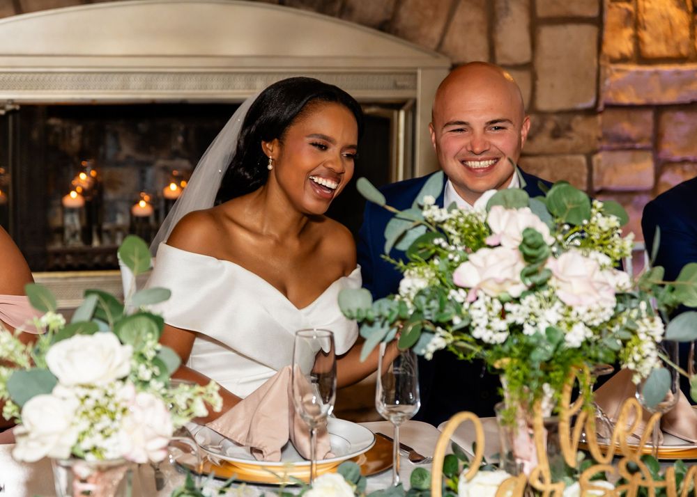 Wedding reception table decorated with elegant white floral centerpieces and warm lighting.