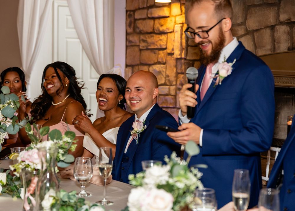 Wedding reception with guests enjoying dinner at elegantly decorated tables.