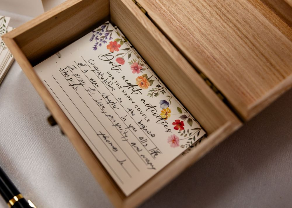Close-up shots of handwritten wedding notes in wooden boxes.