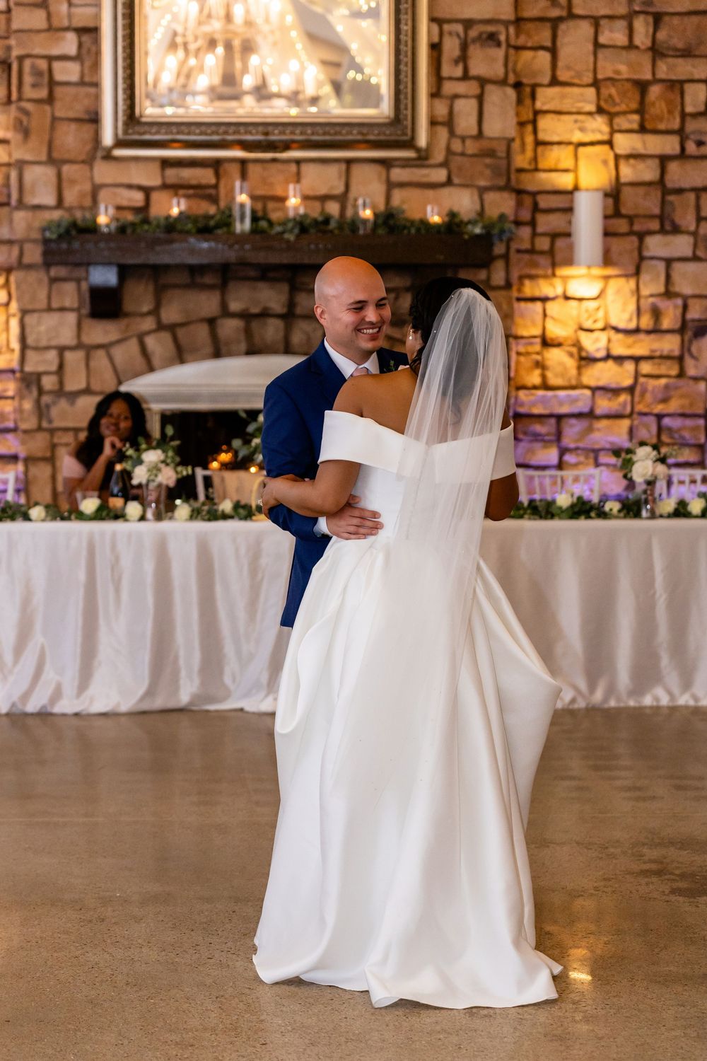 Couple performs their first dance in an elegant stone-walled reception venue.