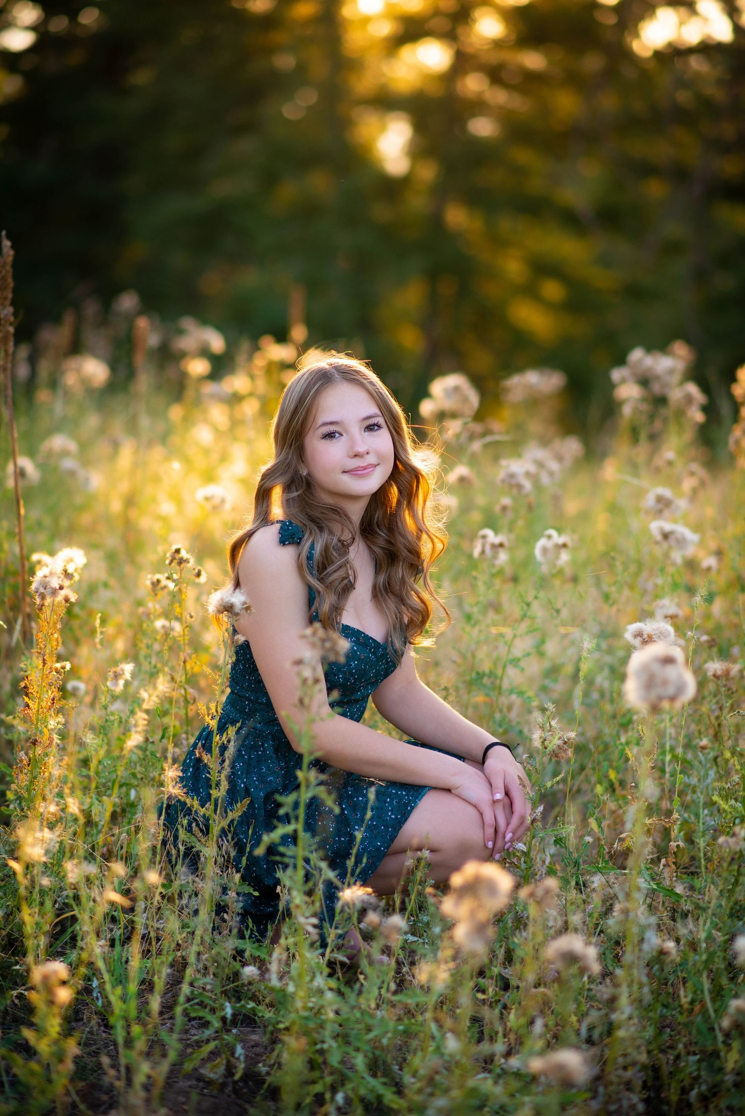 Woman in blue dress poses among wildflowers during golden hour.