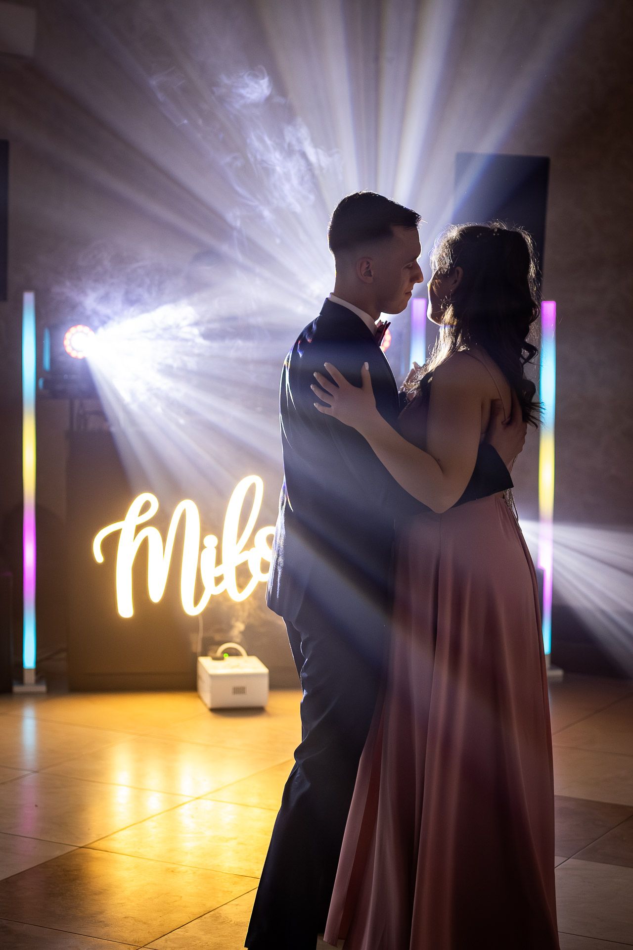 Romantic dance scene with dramatic lighting and neon signage creating an atmospheric mood.